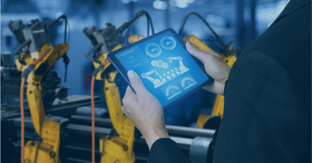 Tablet with a control interface in front of industrial robots in a factory