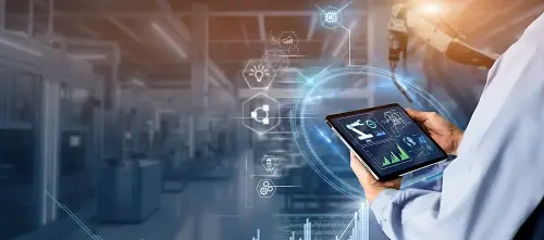 Hand holding a tablet in a production hall, with digital symbols for connected production data above it